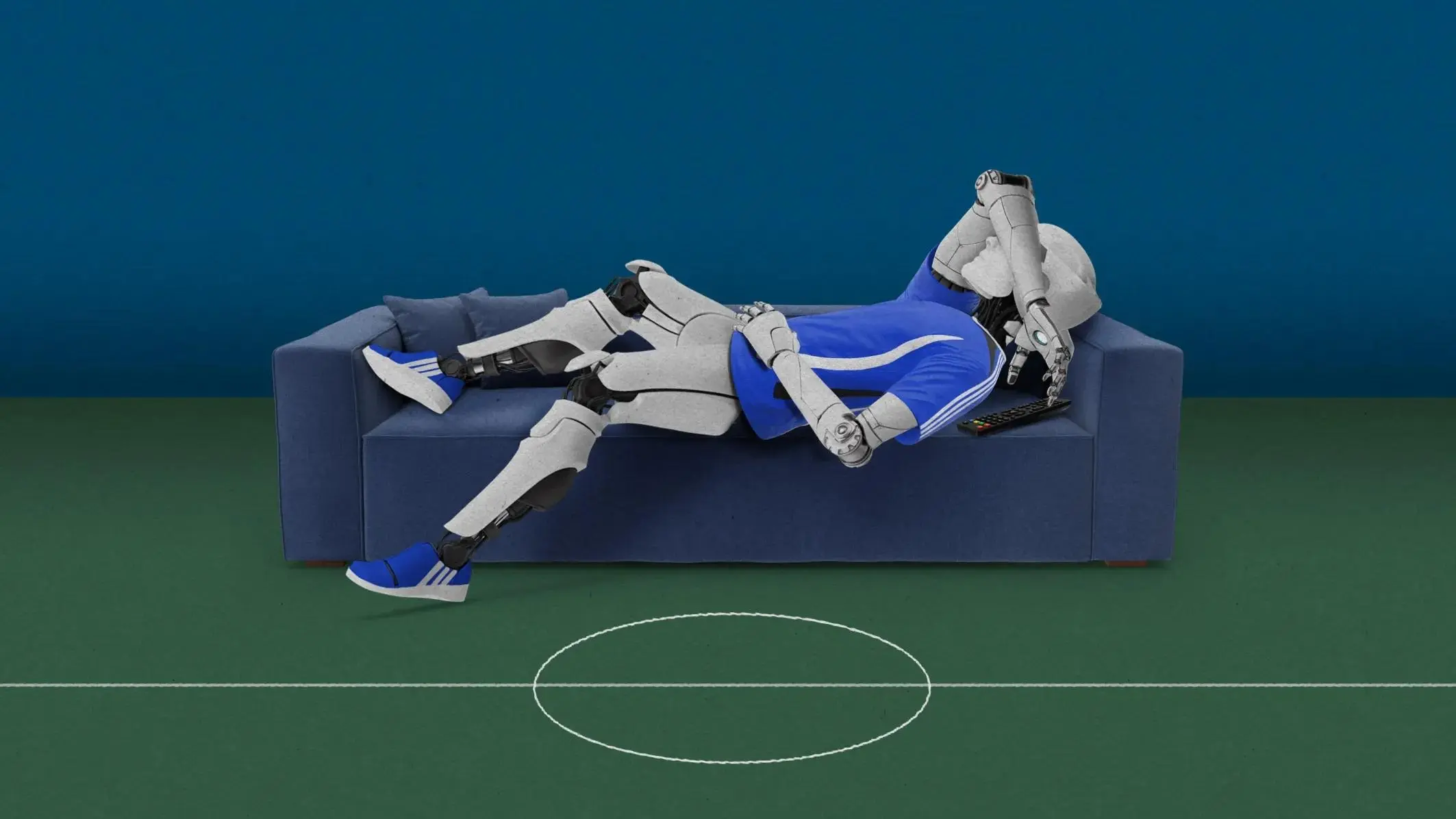 Robot figure lying on blue and white sofa above green soccer field.