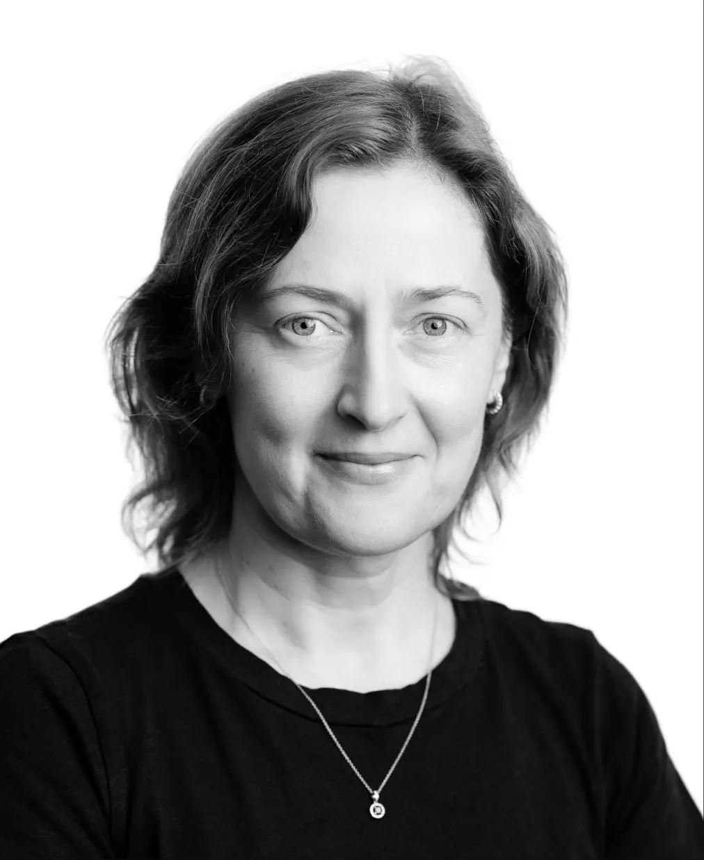 Black and white headshot portrait of a woman with shoulder-length dark hair and necklace, against white background.
