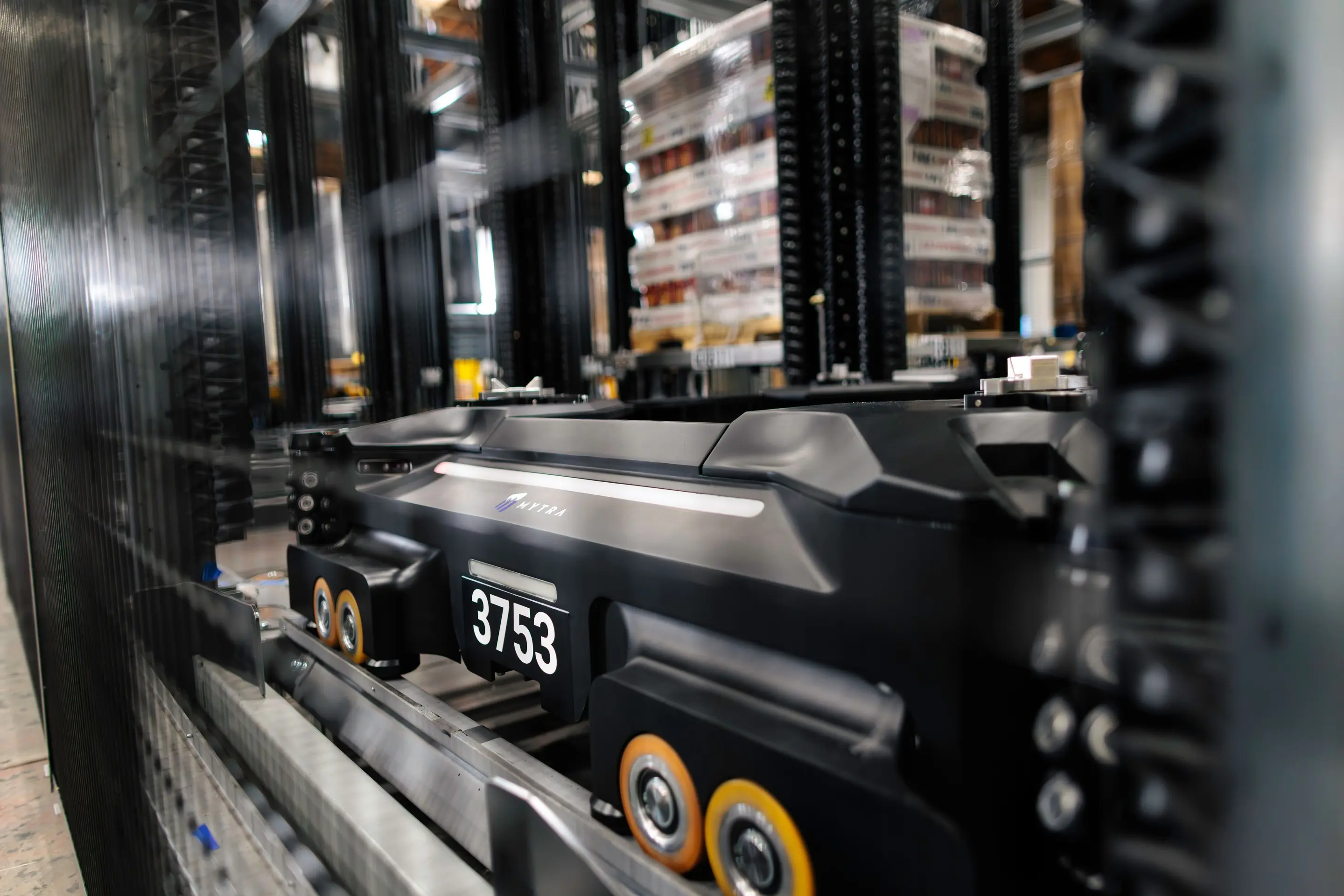 Industrial forklift with black body and yellow wheels in warehouse