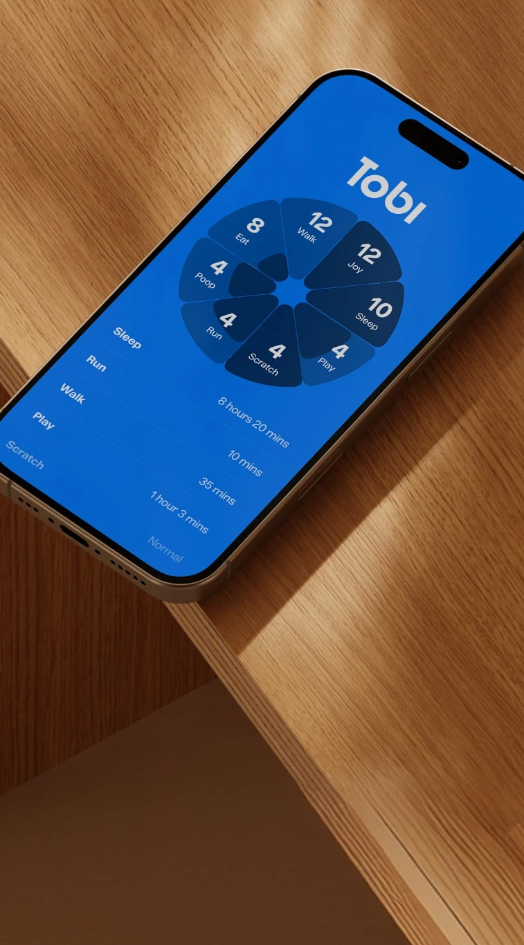 A phone on a wooden table showing the Tobi app's activity wheel