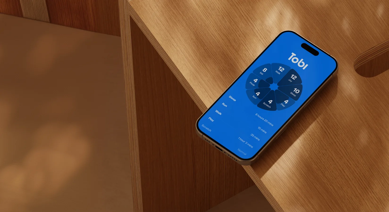 A phone on a wooden table showing the Tobi app's activity wheel