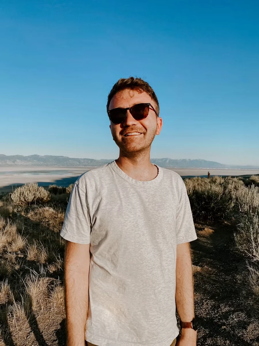 Her owner, in sunglasses, on a hillside